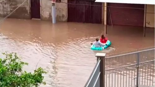 Pareja cruza calle inundada en balsa y se vuelve viral en Cochabamba